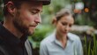© Bussakon - A man wearing a cap and a woman in a light shirt collaborate in a serene garden setting