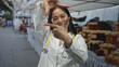 © Krakenimages.com - Young chinese woman doctor with stethoscope in outdoor street market smiling playfully forming square with hands