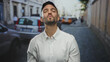 © Krakenimages.com - Young man smiling on a bustling city street, capturing the lively essence of urban life in an outdoor setting with parked cars lining the urban scene in a vibrant neighborhood.