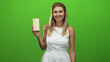 © Krakenimages.com - Blonde woman holds white chocolate bar with bare hand, smiling and presenting, wearing white dress in studio; happiness indulgence.