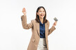 © sitthiphong - Happy young Asian businesswoman holding credit cards and a confident smile isolated on white studio background.