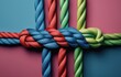 © Volha - colorful ropes tied in a knot on split background empty space concept of unity, business