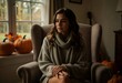 © Michael - A young woman sits calmly in a cozy sweater, surrounded by autumnal decorations and soft natural light.