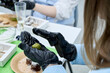© Bondgofoto - Hands in black nitrile gloves making green matcha truffle ball during culinary master class with chocolate desserts and coconut flakes on table in professional pastry workshop or home kitchen.
