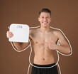 © New Africa - Man happy with his weight loss result on brown background. Outline around his body representing previous body shape