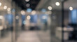 © birulaut - Blurred view of a modern office interior with glass partitions and soft lighting. The space appears professional and contemporary, designed for work.
