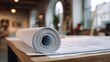 © Kundy - drafting. Architectural blueprint roll on a drafting table in a minimalist studio with natural lighting. real-estate listings.