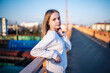 © Довидович Михаил - Young girl relaxing on city bridge at sunset, enjoying urban outdoor lifestyle