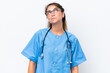 © luismolinero - Young nurse doctor woman isolated on white background and looking up