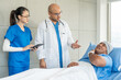 © Chanakon - Doctor team visiting man cancer patient with care and compassion in hospital room. Oncology support medical consultation healthcare and hope. Doctor reporting medical test results to the patient