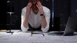 © rogerphoto - Stressed businessman suffering from overwhelming burnout and work overload, working late into the night, feeling frustrated with deadline pressure in a dark office environment