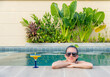© ADDICTIVE STOCK - Woman relaxing by the poolside during summer