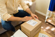 © AntonioDiaz - Entrepreneur packaging small business ecommerce orders from home for delivery, preparing cardboard shipping boxes