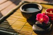 © pham - 竹マットの上で花や石と一緒にお茶を楽しむ