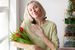 © Tatyana Gladskih - Attractive Woman Smiling While Receiving Beautiful Flower Bouquet In Cozy Indoor Setting, female looks gratefully at the camera