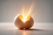 © Nisar's Designs - Cracked egg with bright light emanating from inside on a gray background, symbolizing new life and energy