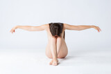 Natural beauty concept, young nude woman with long hair sitting on white background, skincare, body care and wellness