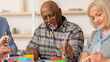 © Prostock-studio - People gather at a community center to participate in an art activity. They are painting and smiling while focused on their art. The atmosphere is friendly and lively.