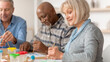 © Prostock-studio - Three seniors participate in a painting session. They use brushes and colorful paints on paper. The setting is bright and casual, encouraging creativity and social interaction among them.