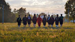 © Довидович Михаил - Students in graduation attire walking hand in hand through a field at sunset