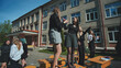 © Довидович Михаил - Female students celebrating the end of the school year standing on their school desks in the schoolyard
