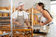 © JackF - Concerned young man seller serves girl buying fresh croissants in bakery store