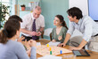 © JackF - Positive young students and a teacher playing educational board game during a classroom workshop