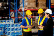 © ultramansk - Professional logistics team planning distribution operations in modern storehouse. Diverse workers and manager checking commercial packages for safe freight delivery.