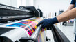 © Andres Mejia - Worker operating wide format plotter printing colorful advertising