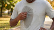 © Darren - A man pulling on his heavily sweaty t-shirt after a vigorous outdoor workout session.