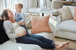 © peopleimages.com - Mom, pregnancy and sofa with toddler in home for playful childhood or parenthood together. Happy, pregnant woman and holding son with smile for maternity, growth development or youth in house