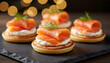 © Jim - Smoked salmon appetizers arranged on slate. Small cornbread cakes topped with cream cheese, salmon, and dill. Cozy bokeh lights add festive atmosphere for parties or events. Gourmet Party Appetizers