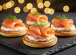 © Jim - Smoked salmon appetizers arranged on slate. Small cornbread cakes topped with cream cheese, salmon, and dill. Cozy bokeh lights add festive atmosphere for parties or events. Gourmet Party Appetizers