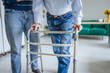 © Miljan Živković - Caregiver assisting elderly person with mobility walker indoors