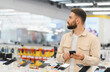 © Serhii - Customer comparing smartphones in electronics store