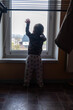 © phpetrunina14 - Toddler silhouette reaching toward window at home.