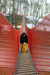 © phpetrunina14 - Father holding toddler on red suspension bridge in winter forest.