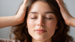 © Denis Yevtekhov - Close-up of a faceless young Caucasian woman's hands resting gently over her head, eyes closed, in a peaceful meditative relaxation pose, defocused soft neutral background, stress-free hands,