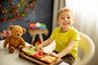 © Tomsickova - Cute little preschool child, boy, eating dried fruits at home, strawberries, melon, pineapple