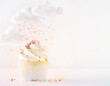 © Ai Stock Lab - Whimsical fluffy white clouds raining colorful sweet sprinkles over delicious vanilla frosted cupcake close up creating joyful and delightful playful dessert scene with light pastel background