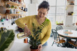 © ReeldealHD images - Young Woman Watering Plant in Kitchen