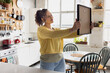 © ReeldealHD images - Young woman planning where to hang a picture in her new home