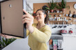 © ReeldealHD images - Smiling Woman ready to hang a picture in her new home