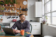 © ReeldealHD images - Young man planning his future working on a laptop in a kitchen