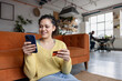 © ReeldealHD images - Young adult woman at home shopping on smartphone mobile