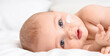 © Pixel-Shot - Cute little baby with cream on cheek lying at home