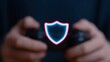 © Business Image - Gaming-Sicherheits- und Cyberschutzkonzept mit Schildsymbol über den Händen des Spielers