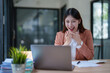 © Tj - Cheerful woman celebrating success on laptop in office