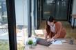 © Tj - Asian businesswoman working on laptop in modern office
