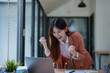 © Tj - Business woman celebrating success working on laptop